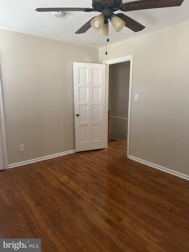 unfurnished bedroom with ceiling fan and dark hardwood / wood-style floors