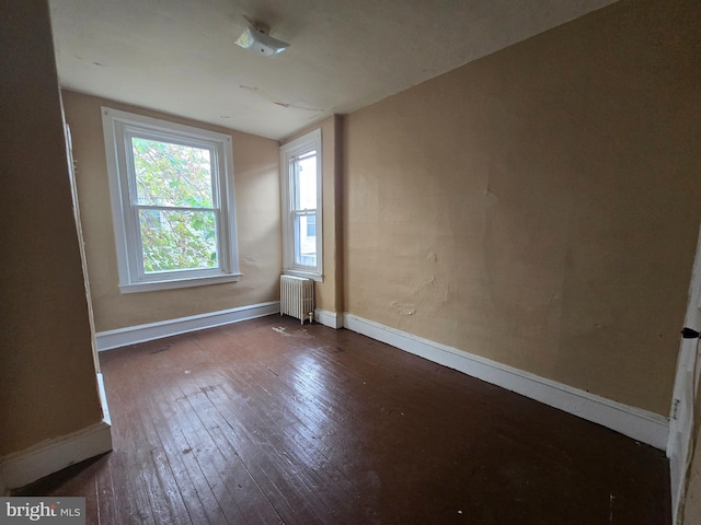 unfurnished room featuring dark hardwood / wood-style floors and radiator