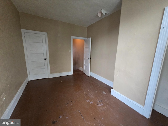 unfurnished bedroom with dark wood-type flooring