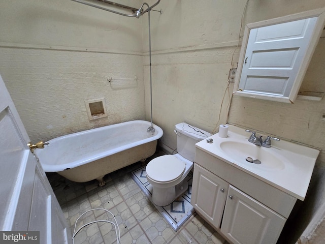 bathroom with a washtub, vanity, and toilet