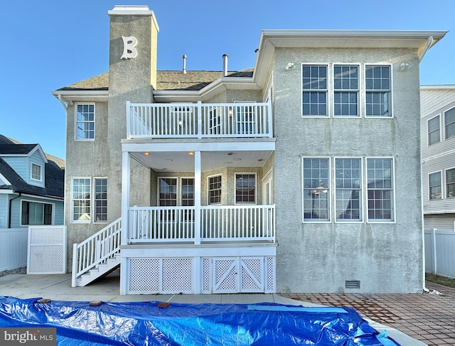 rear view of house with a covered pool