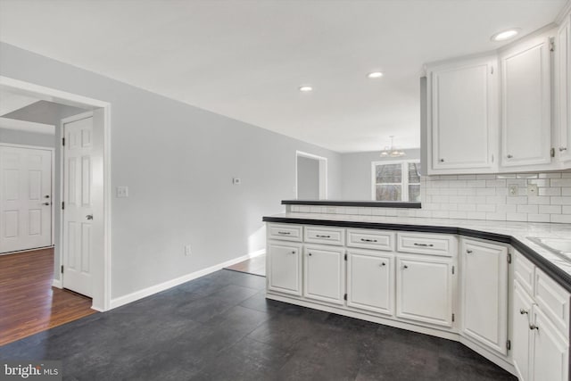 kitchen with decorative backsplash, white cabinetry, sink, and an inviting chandelier