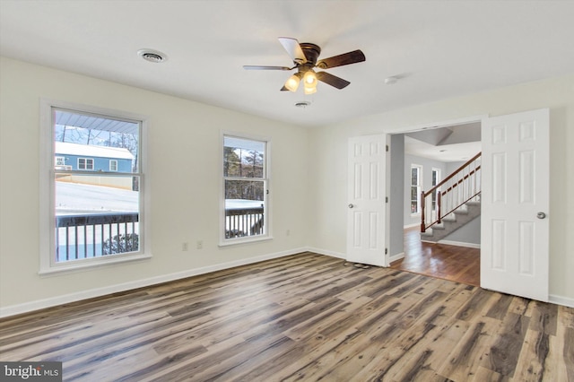 empty room with dark hardwood / wood-style floors and ceiling fan