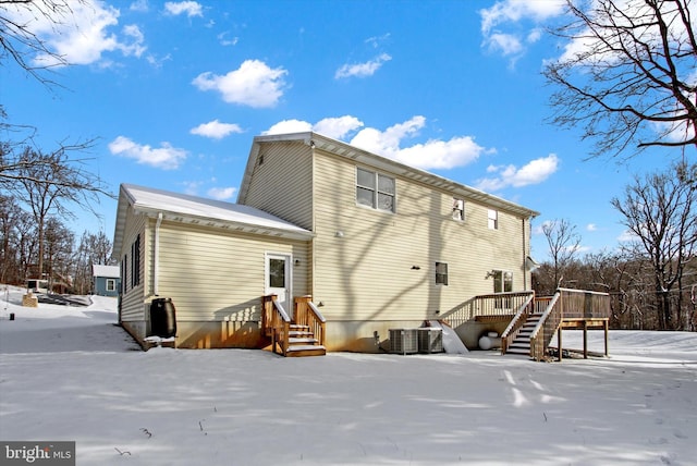 snow covered property with cooling unit