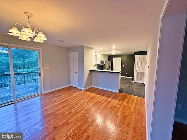 unfurnished living room featuring hardwood / wood-style floors and a notable chandelier