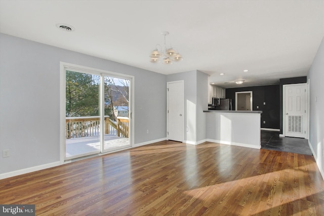 unfurnished living room featuring dark hardwood / wood-style flooring and a chandelier