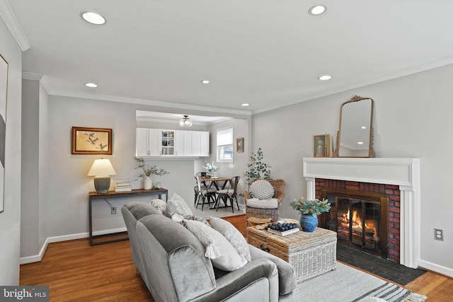 living room with ornamental molding, a fireplace, and hardwood / wood-style floors