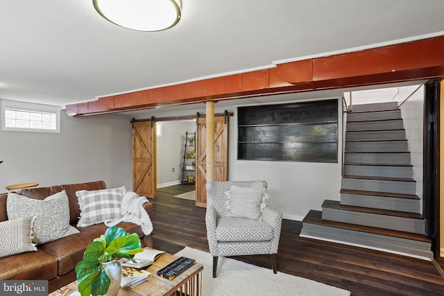 living room with a barn door and dark hardwood / wood-style flooring