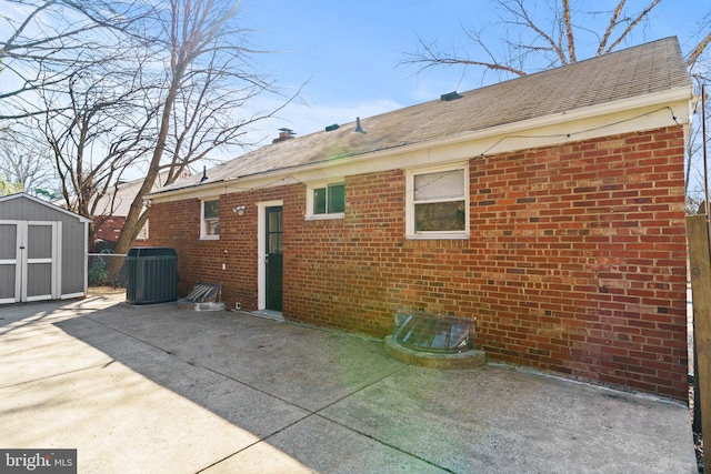 back of property with a storage shed, a patio, and central air condition unit