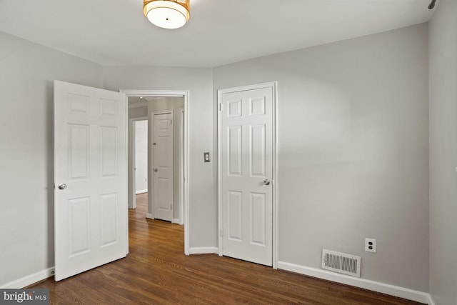 unfurnished bedroom featuring dark hardwood / wood-style flooring and a closet