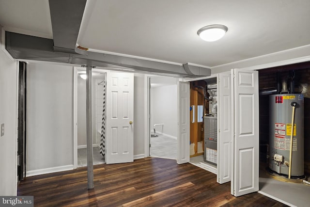 basement with water heater and dark hardwood / wood-style flooring