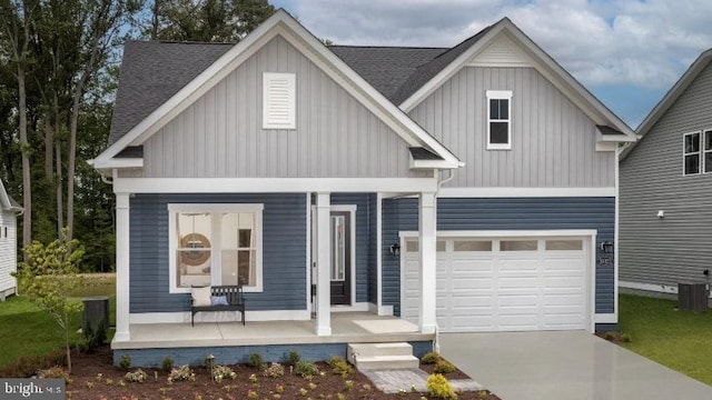 craftsman-style home featuring covered porch, a garage, and central air condition unit