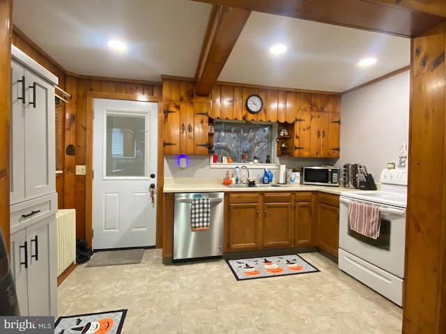 kitchen with appliances with stainless steel finishes, wooden walls, sink, beam ceiling, and radiator heating unit