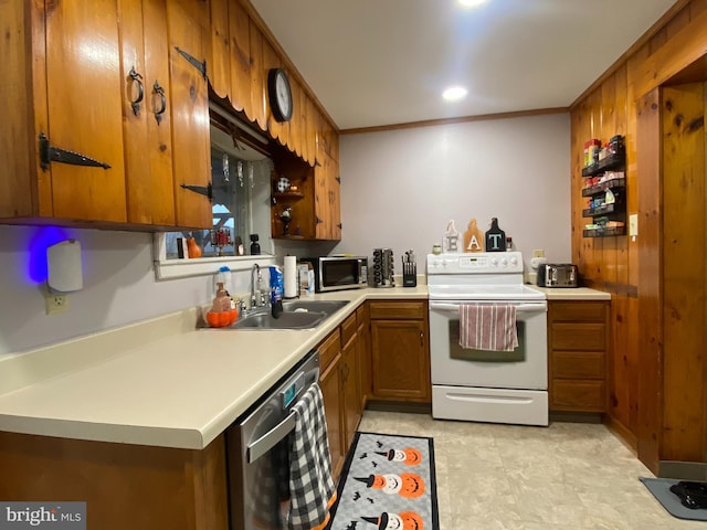 kitchen with kitchen peninsula, sink, ornamental molding, and appliances with stainless steel finishes