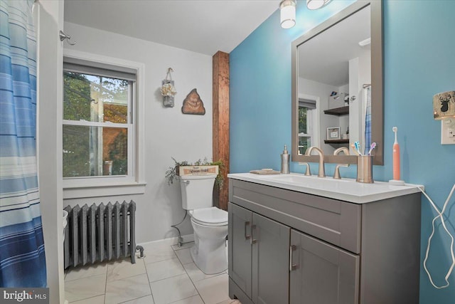 bathroom with vanity, toilet, and radiator