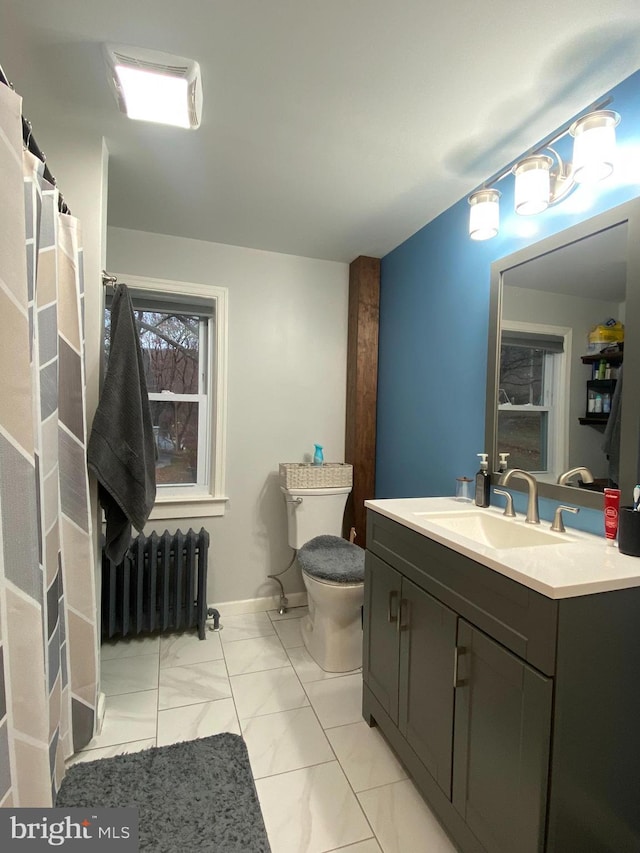 bathroom featuring vanity, toilet, and radiator