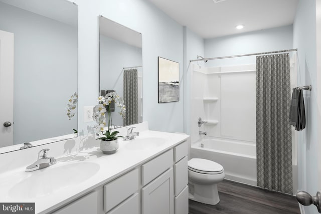 full bathroom with toilet, shower / bath combo with shower curtain, wood-type flooring, and vanity