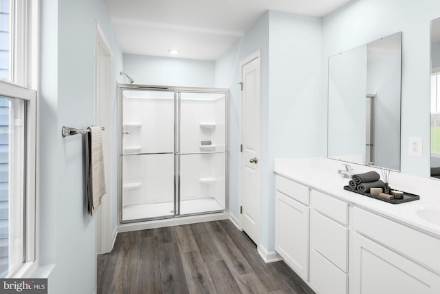 bathroom featuring a shower with door, vanity, and hardwood / wood-style flooring