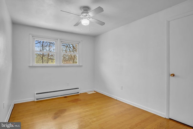 unfurnished room featuring hardwood / wood-style flooring, ceiling fan, and a baseboard heating unit