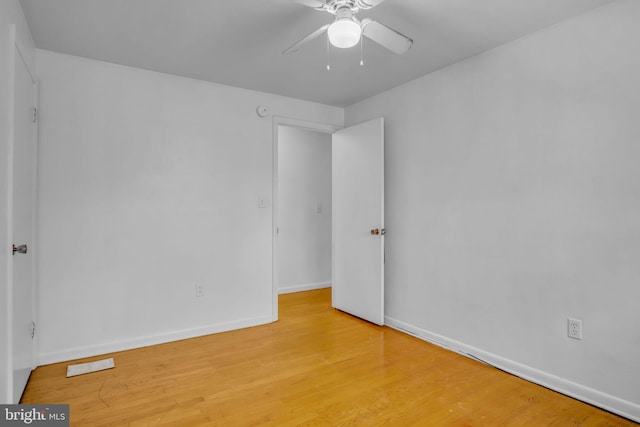 empty room with hardwood / wood-style floors and ceiling fan