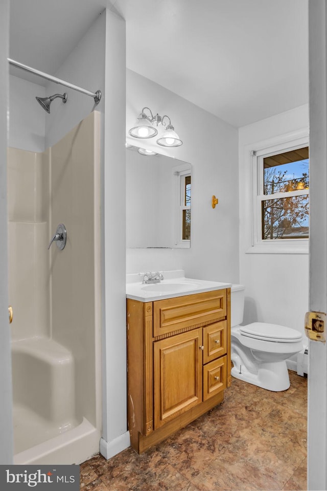 bathroom featuring vanity, toilet, and walk in shower