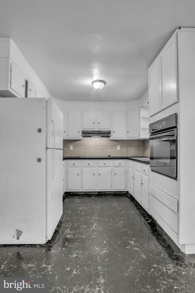 kitchen featuring white cabinets, black oven, white fridge, and backsplash