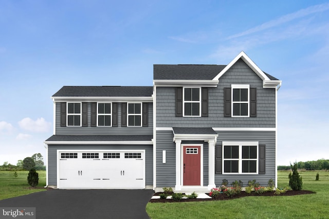 view of front of home with a front yard and a garage