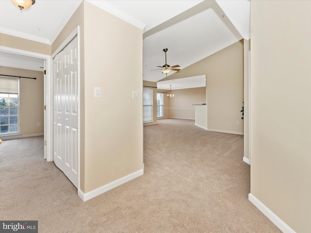 hallway featuring plenty of natural light, crown molding, light carpet, and vaulted ceiling