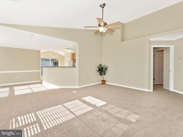 unfurnished living room with ceiling fan, light colored carpet, ornamental molding, and vaulted ceiling