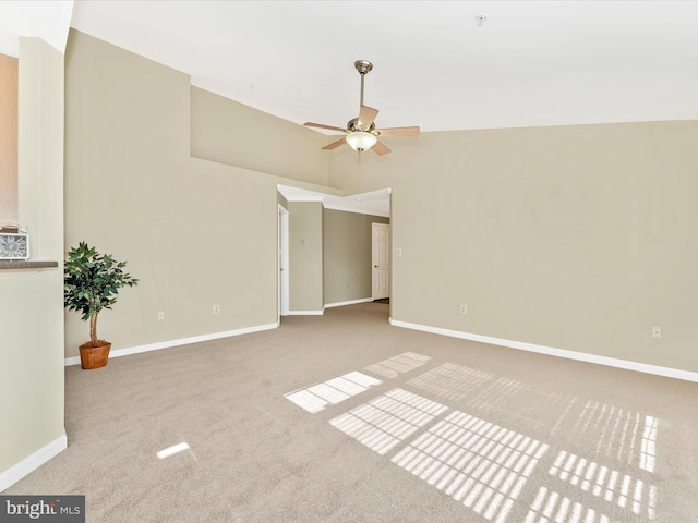 carpeted empty room with ceiling fan and lofted ceiling