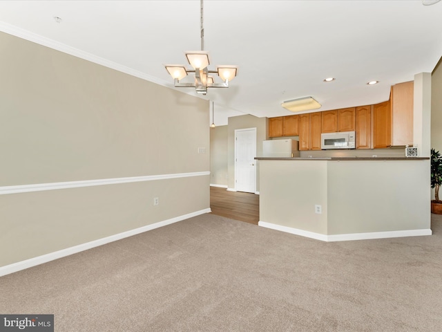 kitchen with carpet, white appliances, crown molding, hanging light fixtures, and kitchen peninsula