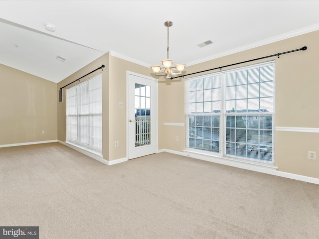 carpeted empty room featuring crown molding and a chandelier