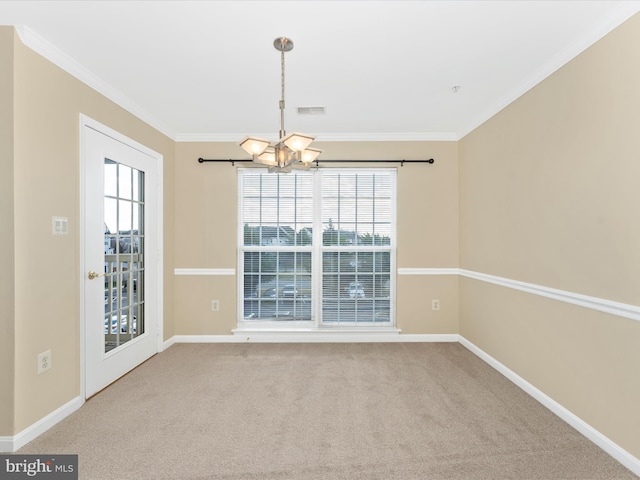 spare room featuring crown molding, carpet floors, and an inviting chandelier