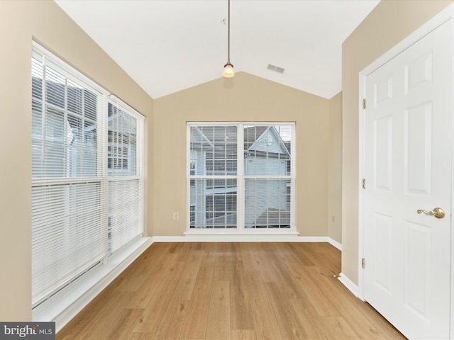 interior space with a wealth of natural light, lofted ceiling, and light wood-type flooring