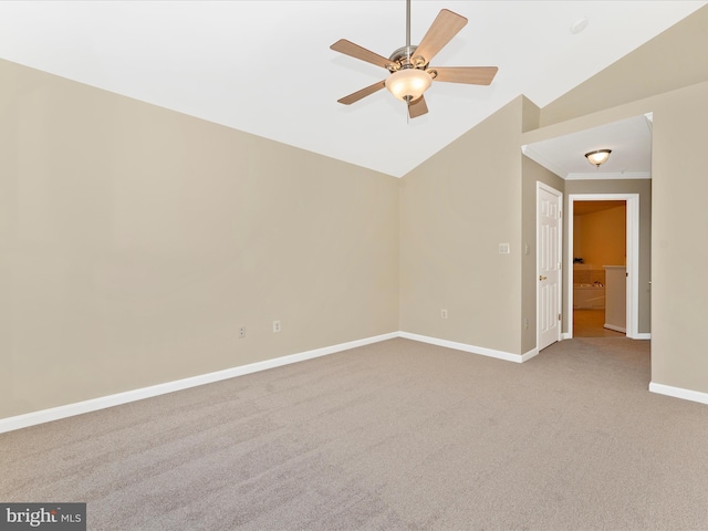 carpeted spare room featuring vaulted ceiling, ceiling fan, and crown molding