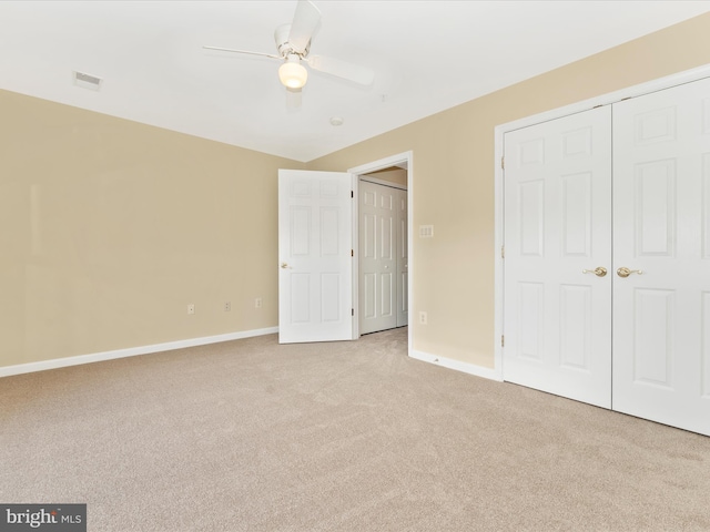 unfurnished bedroom with ceiling fan, a closet, and light carpet