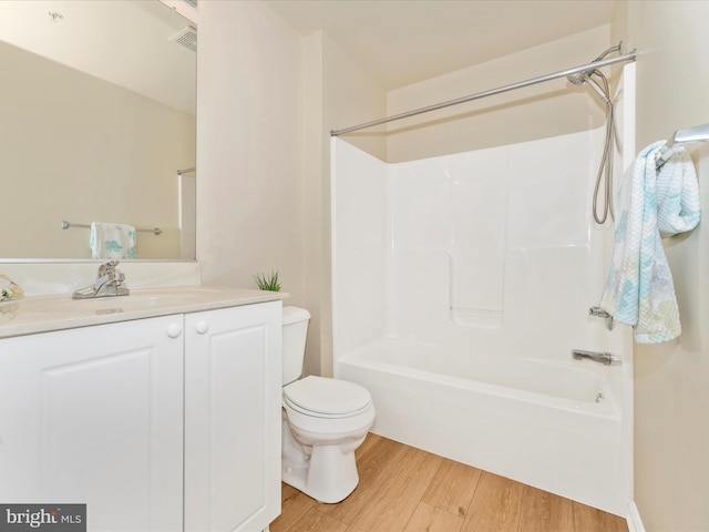 full bathroom featuring vanity, hardwood / wood-style flooring, toilet, and shower / bathtub combination