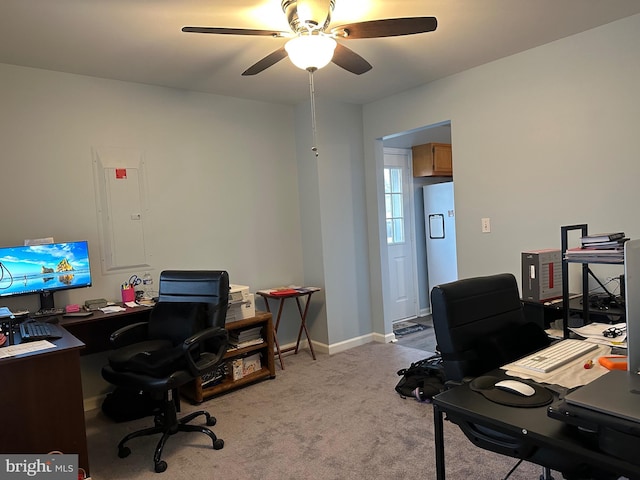 office space featuring light carpet, electric panel, and ceiling fan