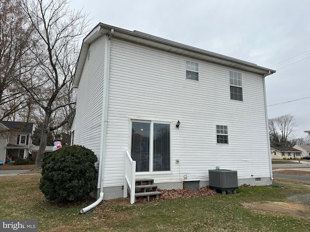 back of property featuring a yard and central AC