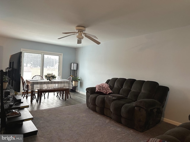 living room featuring ceiling fan and dark hardwood / wood-style floors