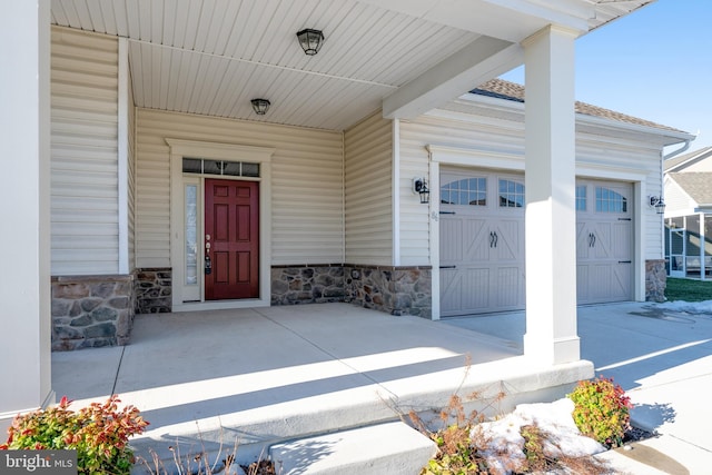 doorway to property with a porch and a garage