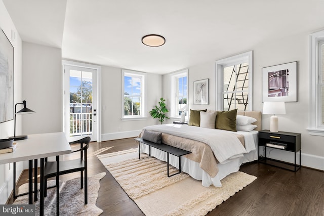 bedroom featuring access to exterior and dark hardwood / wood-style flooring