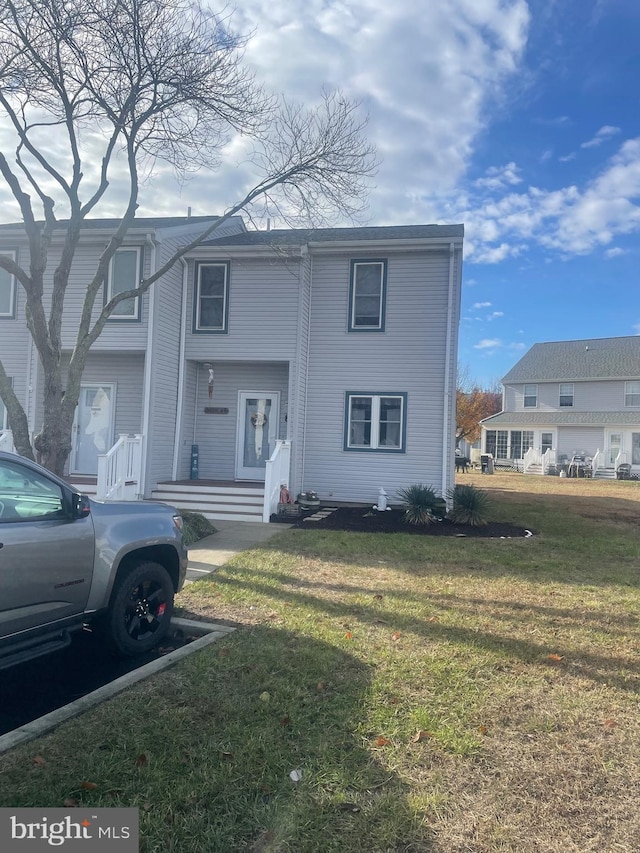 townhome / multi-family property featuring a front lawn