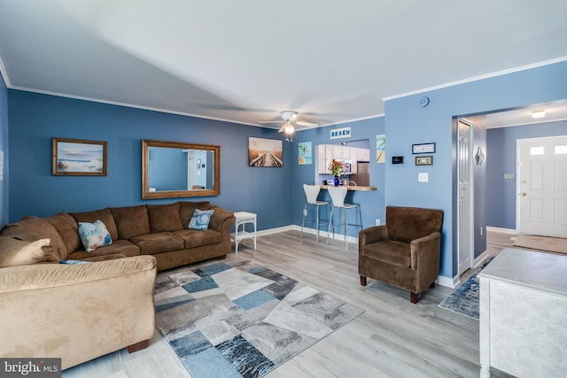 living room with crown molding, hardwood / wood-style floors, and ceiling fan