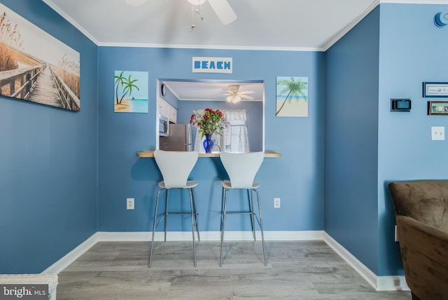 dining space with hardwood / wood-style floors, ceiling fan, and crown molding