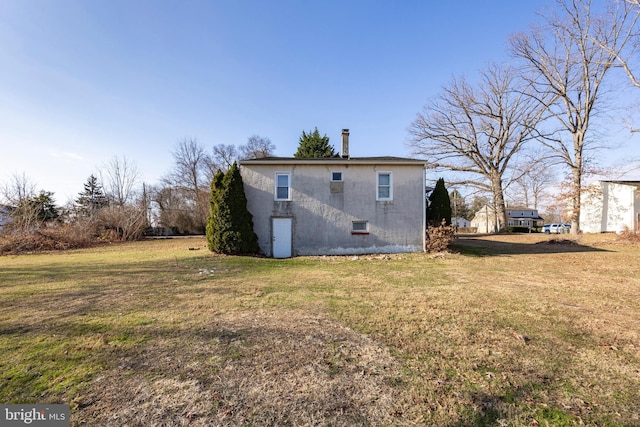 rear view of house featuring a lawn