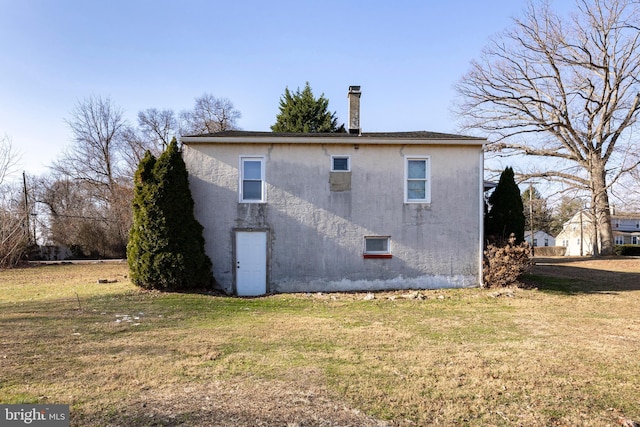 rear view of property featuring a lawn