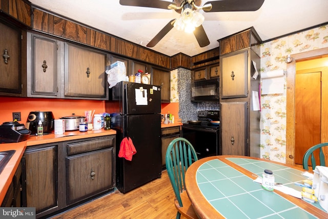 kitchen featuring tile countertops, black appliances, ceiling fan, light wood-type flooring, and dark brown cabinets