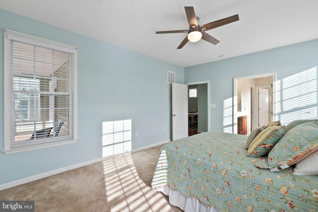 bedroom featuring ceiling fan, ensuite bathroom, and light carpet