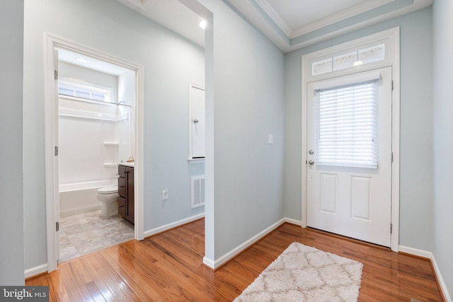 entryway featuring light wood-type flooring and crown molding